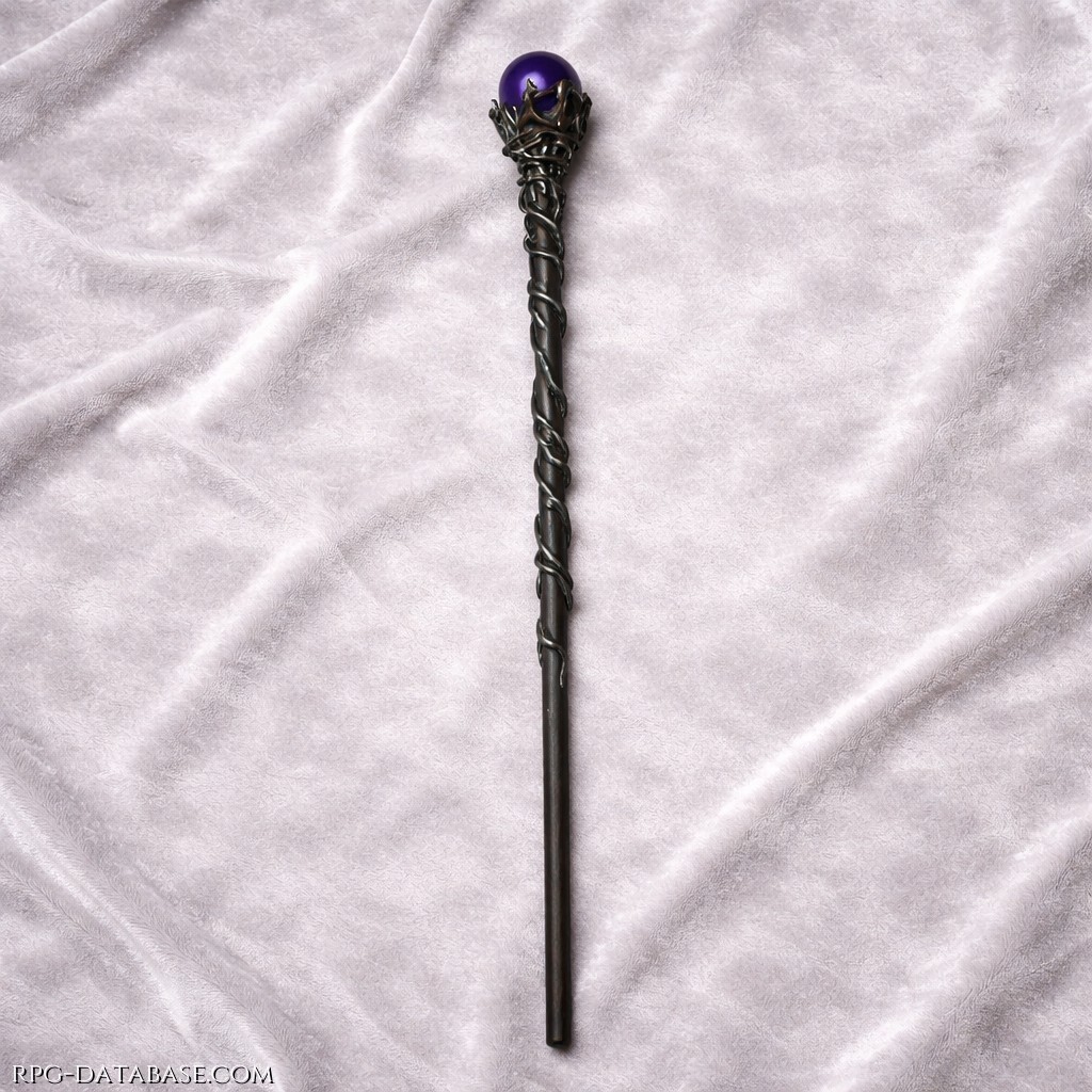 Bastone elegante e sinuoso, scolpito in legno scuro intrecciato come radici vive, con dettagli più chiari che ne esaltano le venature e la lavorazione. La sommità è coronata da una sfera viola profonda, lucida e quasi luminosa, racchiusa in un intreccio metallico che ricorda artigli o rami.