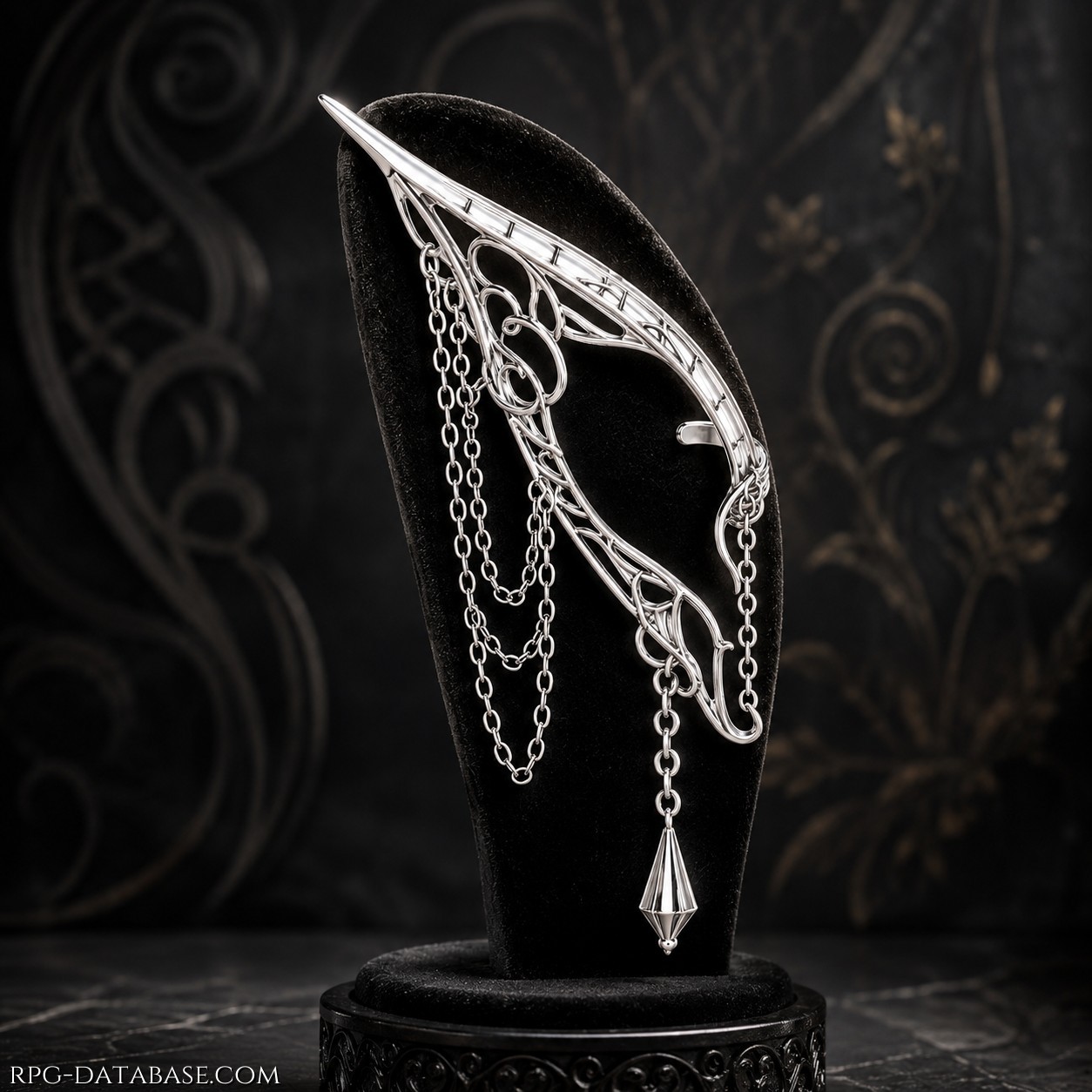 Un elegante orecchino elfico in argento lavorato, dalla forma affusolata e ricca di delicati intrecci ornamentali. Sottili catene pendenti aggiungono movimento, culminando in un piccolo pendente sfaccettato che cattura la luce. Un gioiello raffinato e misterioso, dall’estetica antica e aristocratica.